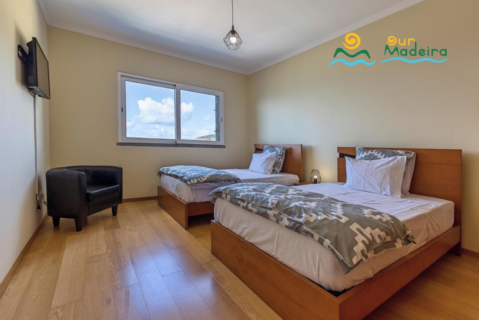 A bedroom with two beds, a sofa, a TV, and a window with a view of the sky.