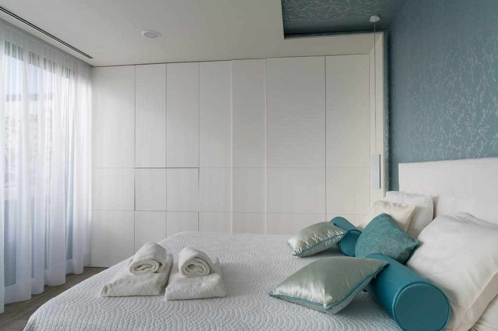 Une chambre d’hôtel moderne avec un grand lit, une armoire et une vue sur la ville.