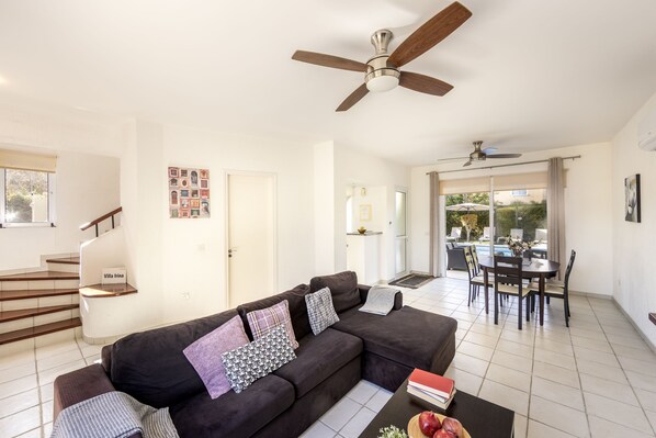 A living room with a sofa, a coffee table, and a ceiling fan.
