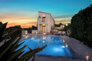 A modern house with a swimming pool, outdoor furniture, and a well-maintained garden. - Countryside Escape w/ Sea View & Ping Pong (Rethymno)