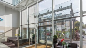 A modern lobby with glass walls, leather seating, and a wooden floor. - Ospreys - With a balcony and within a short walk of the beach (Bournemouth)