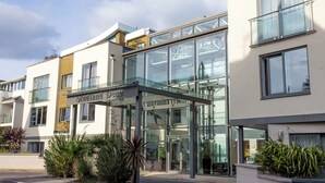 A modern building with a glass entrance and a sign reading "Sudland Deme". - Ospreys - With a balcony and within a short walk of the beach (Bournemouth)