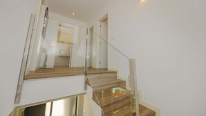A modern staircase with glass railings and wooden steps. - Villa Jade I (Can Picafort)