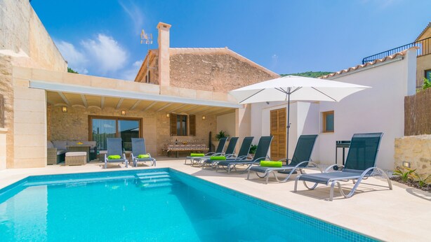 Une piscine avec des chaises longues et un espace salon abrité.
