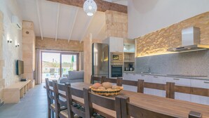 Une cuisine moderne avec un coin repas, comprenant une table en bois, des chaises et un panier de pain.