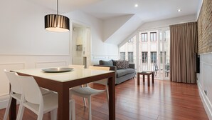 A modern living room with a dining area, a sofa, and a TV. - Penthouse with private terrace in the heart of El Born (Barcelona)
