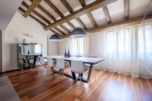 Un comedor con techo de madera, una mesa larga con sillas y una lámpara moderna.