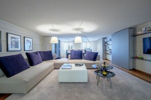A modern living room with a sectional sofa, a coffee table, and pendant lighting.