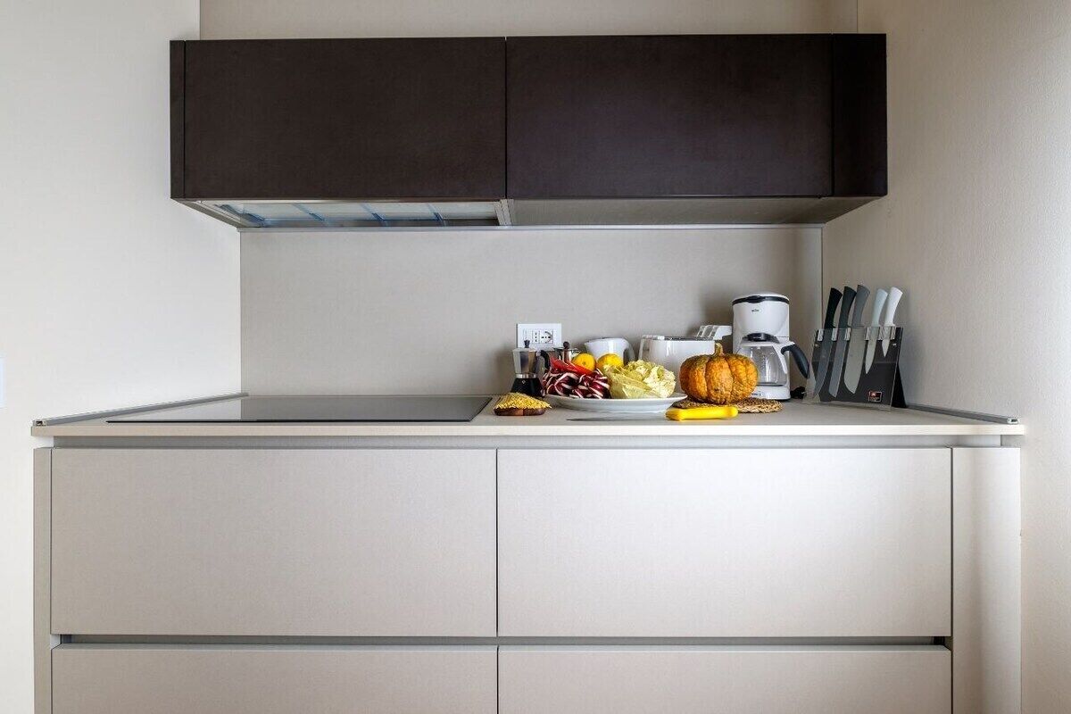 A kitchenette with a microwave, toaster, and a knife block.