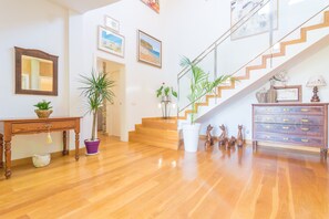Stunning interior with a polished floor, staircase, and artwork-adorned walls.
