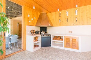 Kitchen area with central stove, sink, and cabinetry, offering a convenient space for meal preparation.