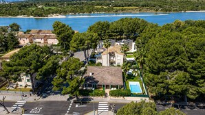 Un quartier résidentiel situé sur la côte, avec des maisons, une piscine et une route où se trouve un panneau de signalisation indiquant un arrêt obligatoire.