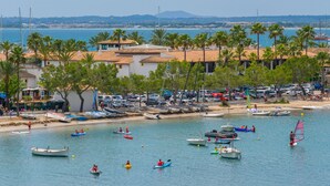 Une ville côtière avec des bateaux, une plage et des palmiers.