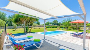 A covered outdoor area with a pool, lounge chairs, and a table with flowers. - ANGIGAL - Spectacular villa with private pool in the tranquility of the countryside. Free (Manacor)