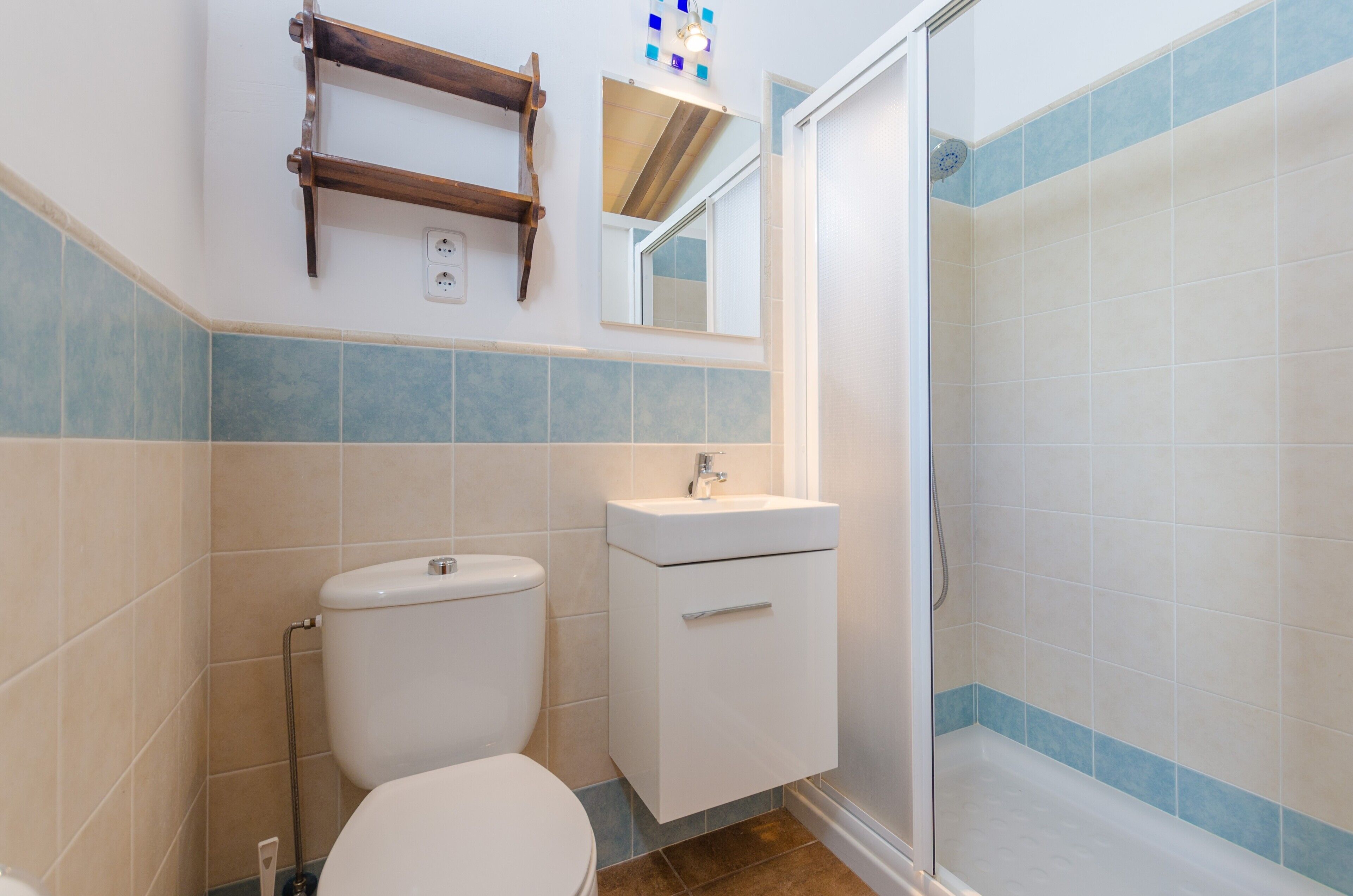 Une salle de bain équipée de toilettes, d’un lavabo et d’une douche.