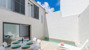 A modern outdoor dining area with a pool, white walls, and a clear blue sky. - NA VALENTA - Villa with private pool in Artà. Free WiFi (Artà)