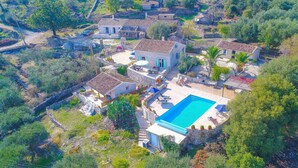 An aerial view of a property with a swimming pool, stone buildings, and surrounding greenery. - Helona: Villa Estate, heated pool, stunning views, A/C (Kelia - Kassiopi)