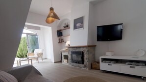 Una sala de estar moderna con chimenea, televisor de pantalla plana y un espacio de descanso acogedor.