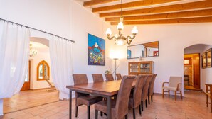 Ein Essbereich mit Holztisch und Stühlen, einer Chandelier und einem Gemälde an der Wand.