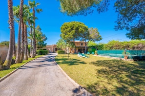 A pathway leading to a building with a large tree in the center, surrounded by greenery and a clear blue sky. - SA MARINA (COVAMARINA) - Villa with private pool in Sa Rapita (Campos). (Llucmajor)