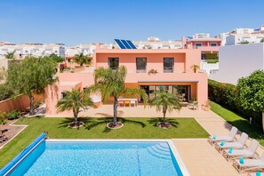 Een verwarmd zwembad, ligstoelen bij het zwembad