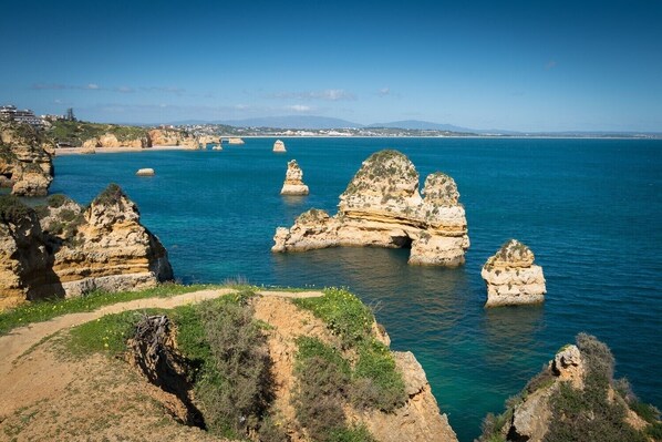 Paisaje costero con formaciones rocosas destacadas y una vista despejada del mar.