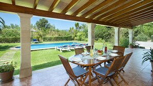 A covered patio with a pool, outdoor dining area, and lush greenery. - VILLA  BOBIS - RUSTIC STAY (Pollensa)