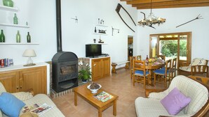 A cozy living room with a fireplace, wooden furniture, and a dining area. - VILLA  BOBIS - RUSTIC STAY (Pollensa)