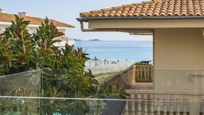 A balcony with a view of the sea, a tiled roof, and a glass railing. - Villa Alicemar beach (Puerto de Alcudia)