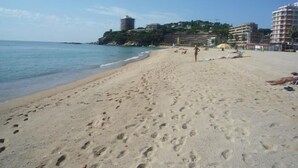 A beach with footprints, a person walking, and buildings in the background. - Villa Torre Gavarres, Calonge - Costa Brava (Calonge)