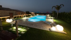 A swimming pool with lounge chairs and a pergola, surrounded by a well-maintained lawn and stone pathway. - VILLA FENICOTTERO RELAX AND EXCLUSIVE POOL (Ispica)