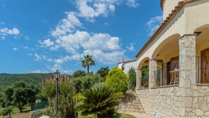 A stone building with a balcony, surrounded by lush greenery and a clear blue sky. - Villa Bunganvilla, Calonge - Costa Brava (Calonge)