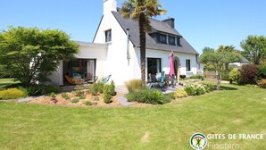A modern two-story house with a white exterior, a dark roof, and a well-maintained garden with various plants and a palm tree. - Ma Maison à La Mer, Fouesnant, Brittany (Fouesnant)