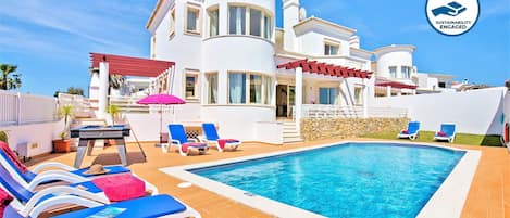 A heated pool, sun loungers