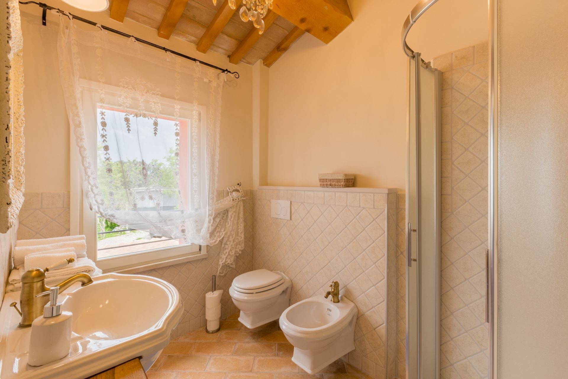 Une salle de bain avec un grand lavabo, deux toilettes, un bidet et une douche.