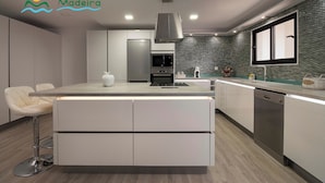 A modern kitchen with a central island, built-in appliances, and a backsplash. - 5-bed in Calheta, pool, gym, games room | Rosalina (Calheta)