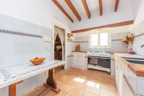 Traditional kitchen with a long countertop, stove, sink, and decorative borders.