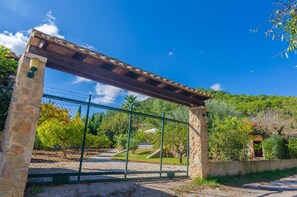 Stately entrance with stone pillars and a metal gate.