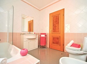 Tina con regadera, secadora de cabello, toallas 