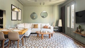 A living room with a sofa, coffee table, and dining table set up. - Luxurious Oasis Paseo de Gracia (Barcelona)