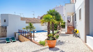 A courtyard with a pool, outdoor seating, and a staircase leading to a building. - Modern downtown apartment [28] (Lagos)