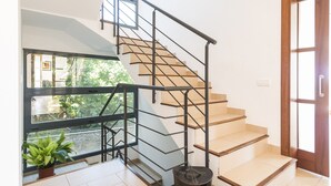Una escalera moderna con barandilla de metal que conduce a un piso superior.