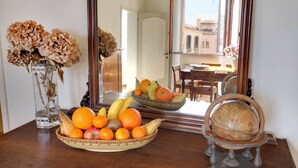 Een eettafel met fruit, een vaas met gedroogde bloemen en een wereldbol.