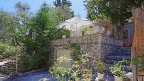 A stone building with a white umbrella, potted plants, and a stone staircase. - Lili Luxury Cottage: Pool, A/C, Wi Fi, lovely gardens (Ozias Gaios)