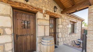 Un edificio de piedra con puertas de madera y un barril.
