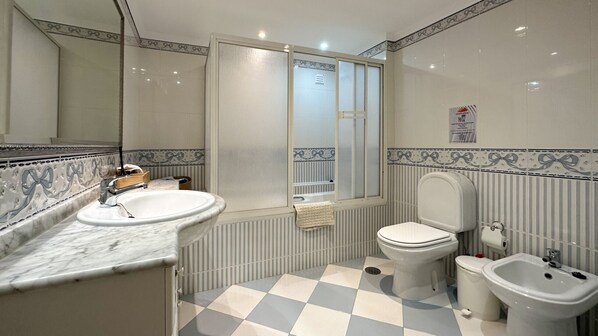 A bathroom with a marble sink, a toilet, a bidet, and a mirror. - Sofeelings Quarto Mar_Piso 2, Baixa de Albufeira (Albufeira)