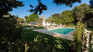 A pool area with a clear view of a building in the background, surrounded by greenery. - Charming Trullo Amarcord with Private Pool, Spa & Park near Alberobello (Selva di Fasano)