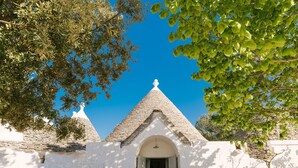 A traditional building with a stone facade, a central arched entrance, and a tiled roof. - Charming Trullo Amarcord with Private Pool, Spa & Park near Alberobello (Selva di Fasano)