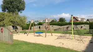 A playground with swings, a slide, and a climbing structure.