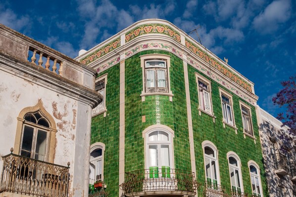 A historic building with ornate architectural details and a green-tiled facade.